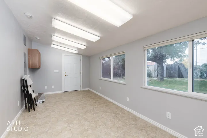 Neutral-toned tile flooring, light gray walls, white trim, and multiple fluorescent ceiling lights