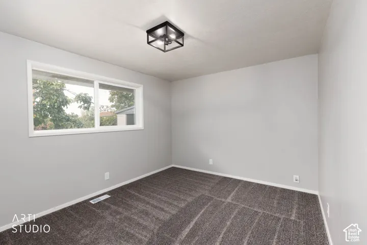 Neutral tone walls, plush carpet flooring, white trim, and a modern flush-mount light fixture