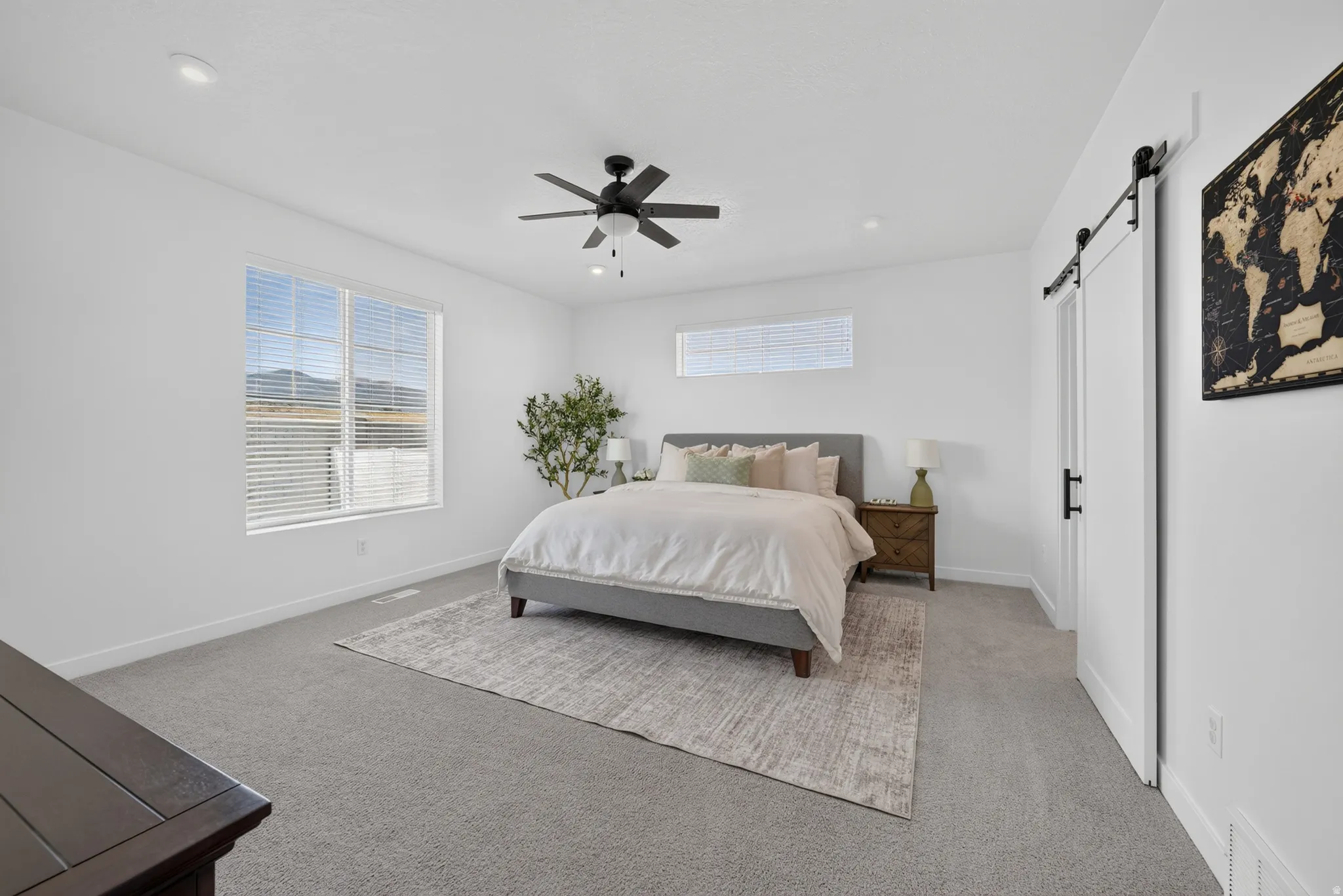 Spacious room with large windows, recessed lighting, and a ceiling fan