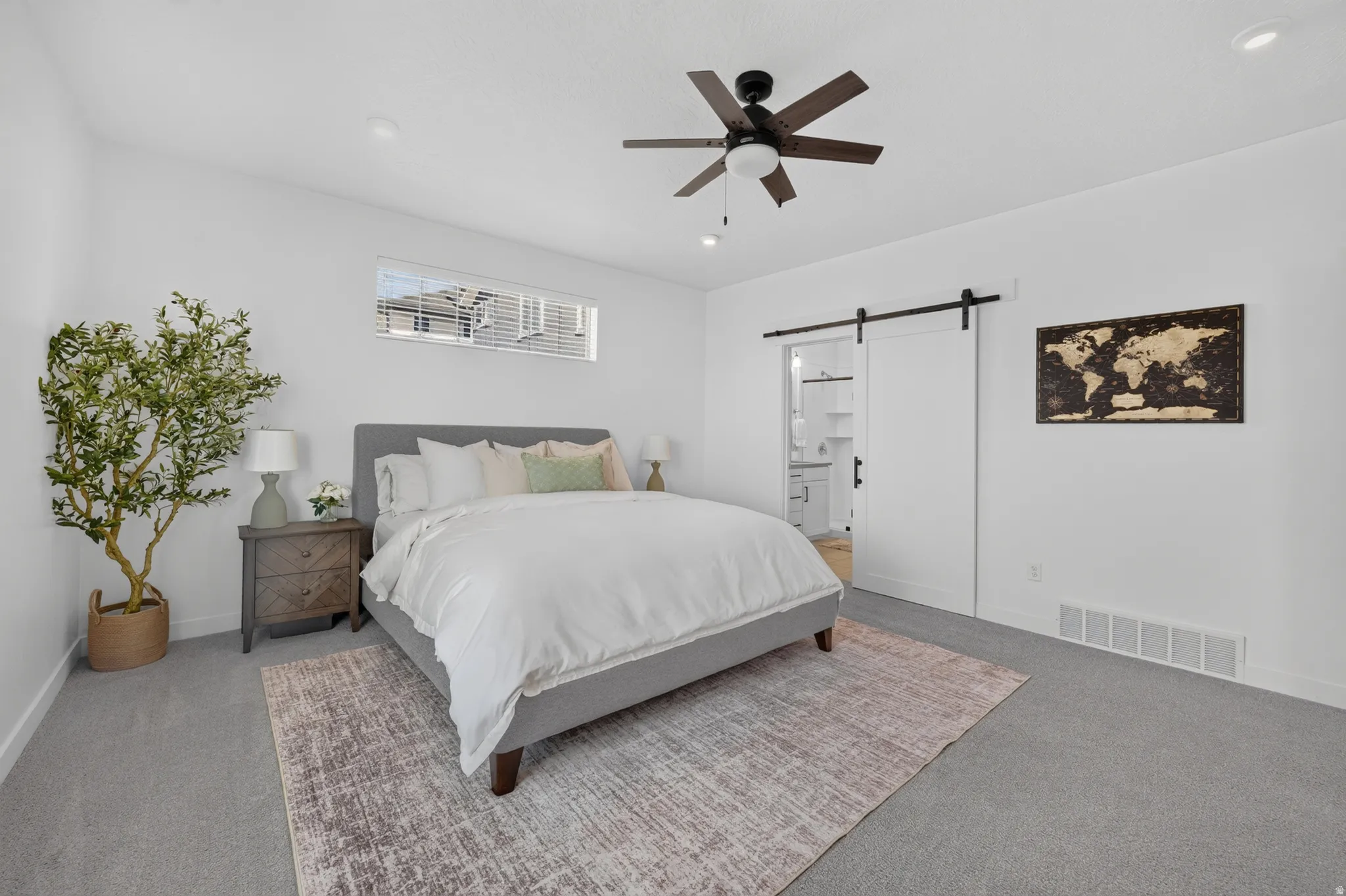 Spacious room featuring a white barn door, recessed lighting, and a ceiling fan