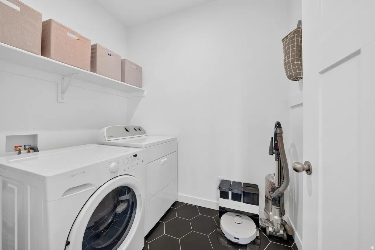 Laundry area with hexagonal floor tiling, white walls, and built-in shelving