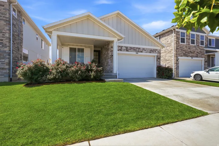 Single-story facade with stone and siding accents, covered front porch, and an attached two-car garage