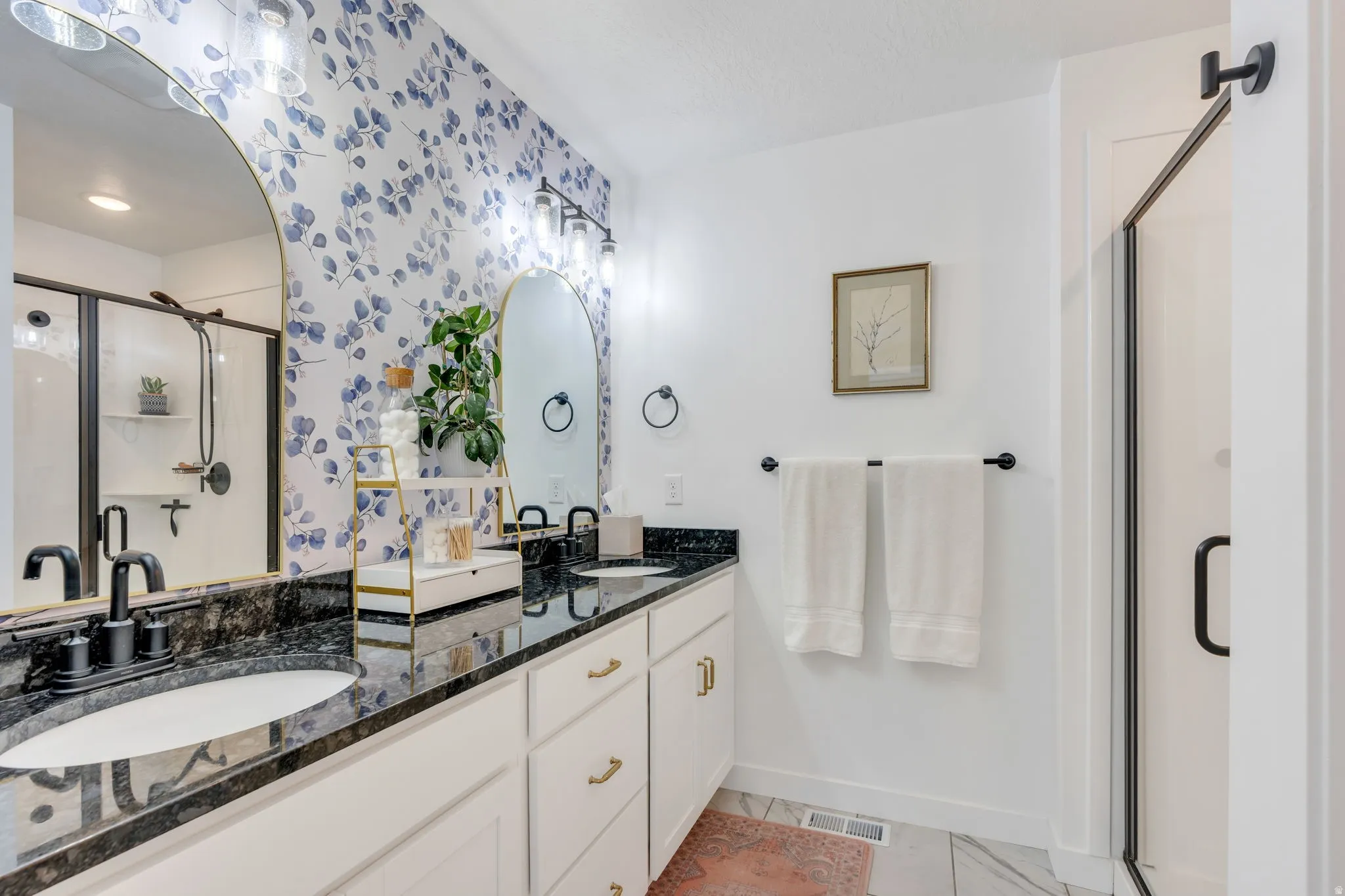 Dual vanity with black stone countertops and undermount sinks