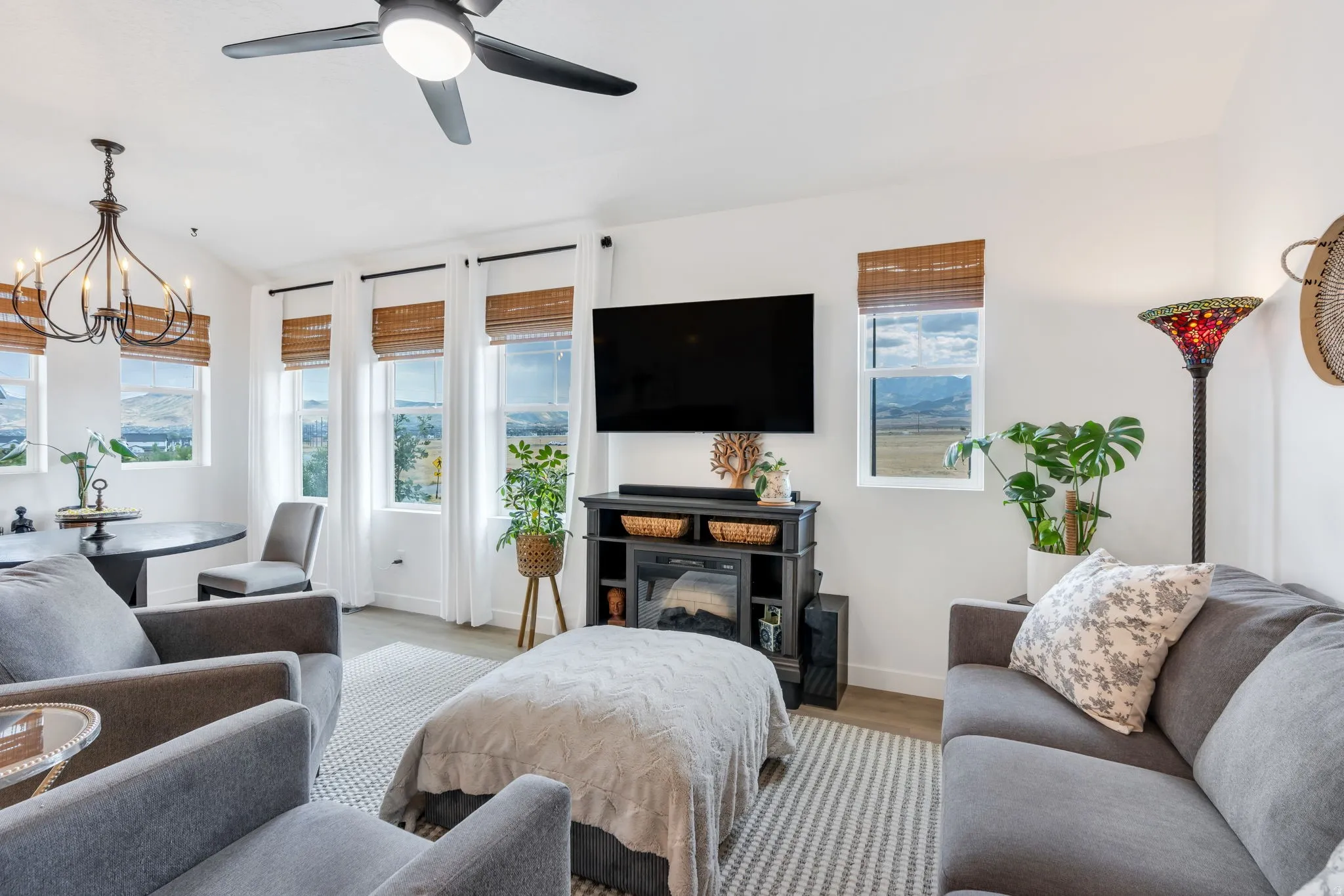Vaulted ceilings, wood-finish flooring, ceiling fan, and a built-in media console with electric fireplace