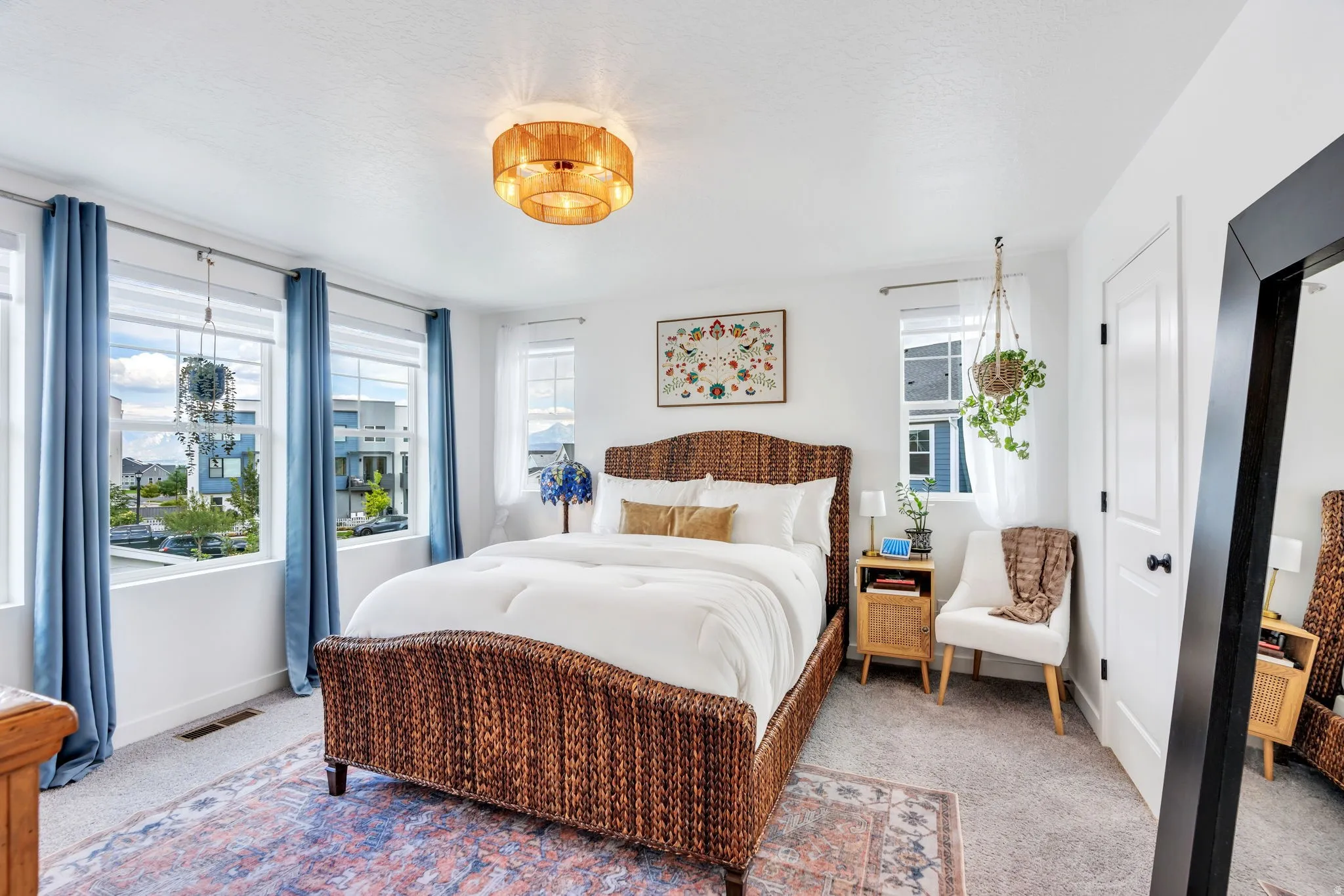 White painted walls, carpeted flooring, multiple windows, a ceiling-mounted light fixture, and a white paneled door