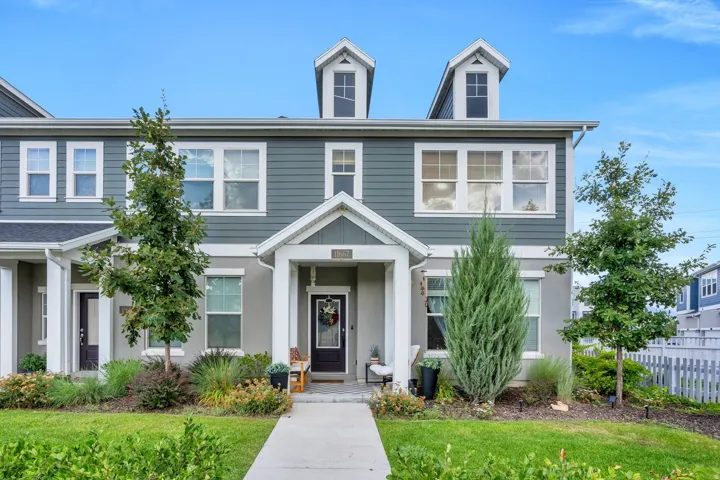 Exterior featuring dormer windows, a covered front porch, and a white picket fence