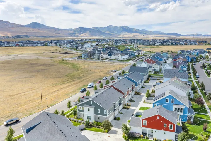 Newly constructed residences with varied exterior finishes, paved roads, maintained landscaping, and mountain backdrop