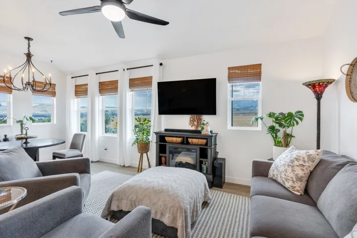 Vaulted ceilings, wood-finish flooring, ceiling fan, and a built-in media console with electric fireplace