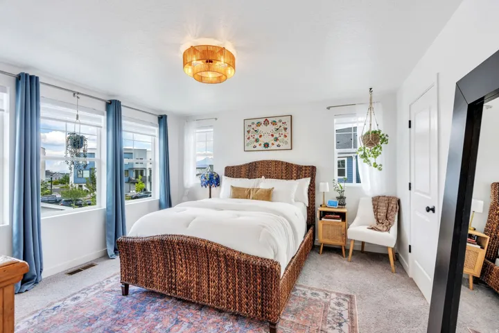 White painted walls, carpeted flooring, multiple windows, a ceiling-mounted light fixture, and a white paneled door