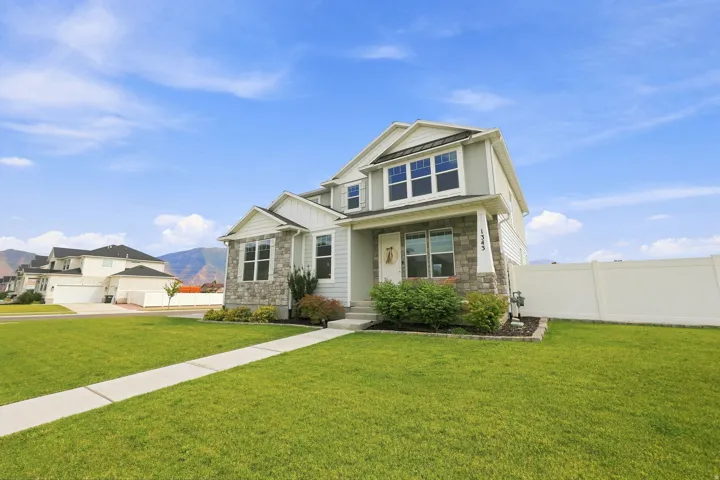 Two-story exterior with light gray siding and stone accents