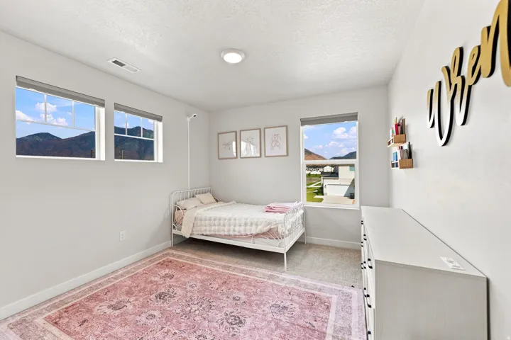 Neutral wall paint, recessed lighting, carpet flooring, multiple windows, and a built-in shelf
