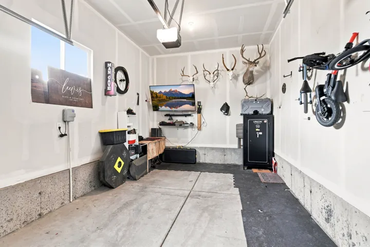 Concrete flooring with a partial black floor mat, overhead garage door opener, and a single window