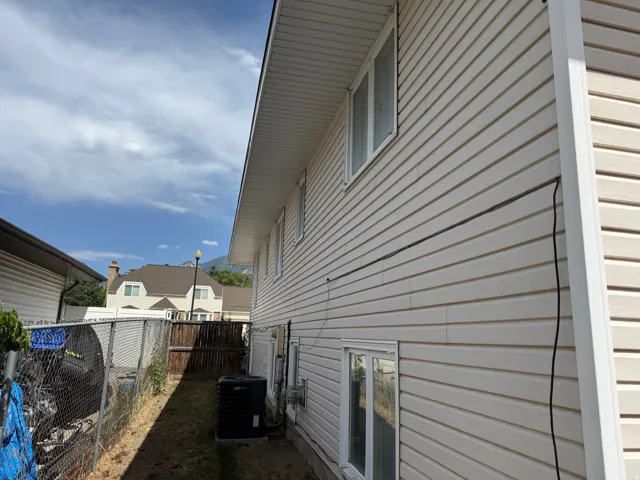 Exterior siding with multiple windows and a visible air conditioning unit