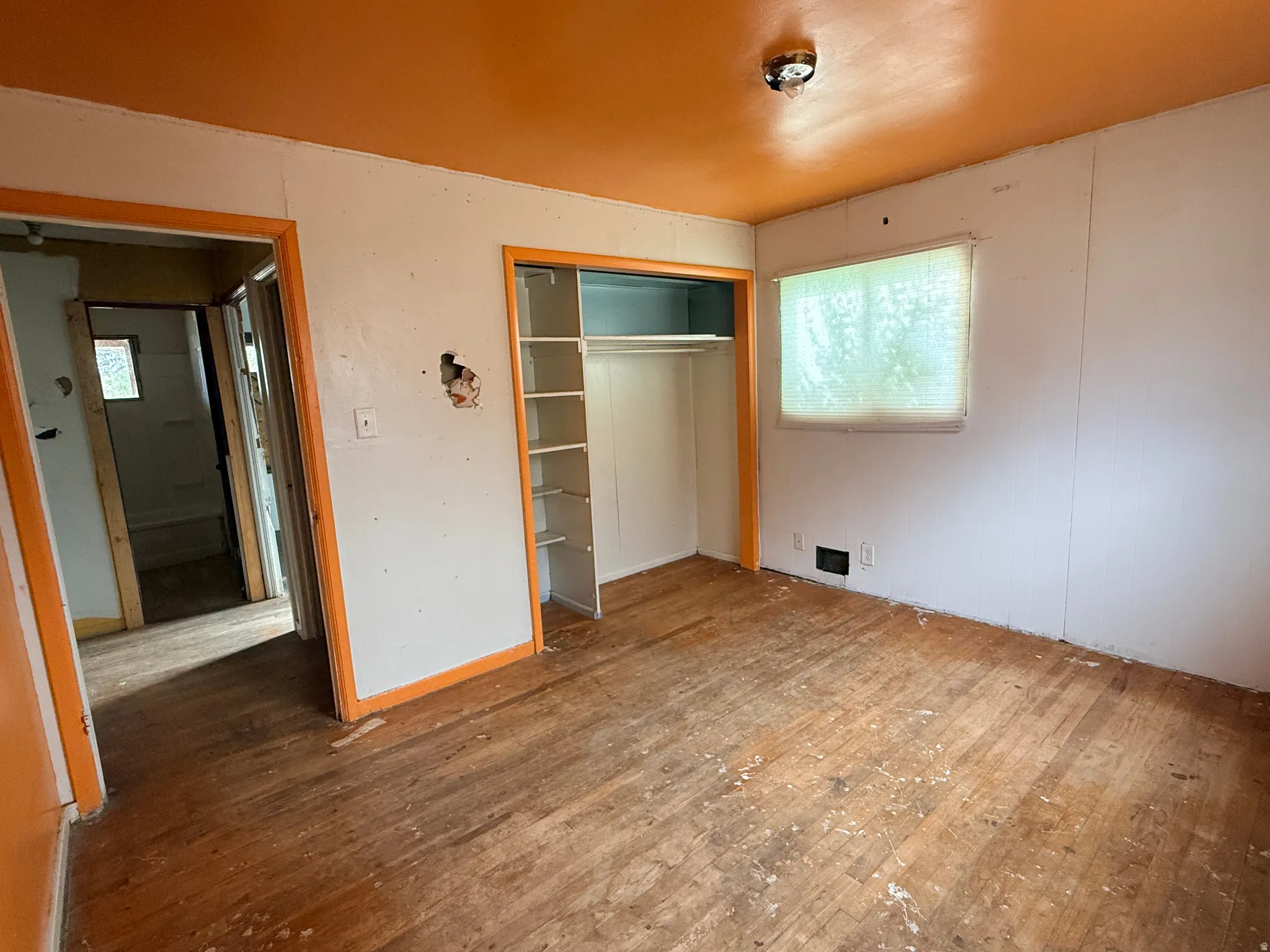 Wood-finish flooring, built-in shelving, and a window with natural light
