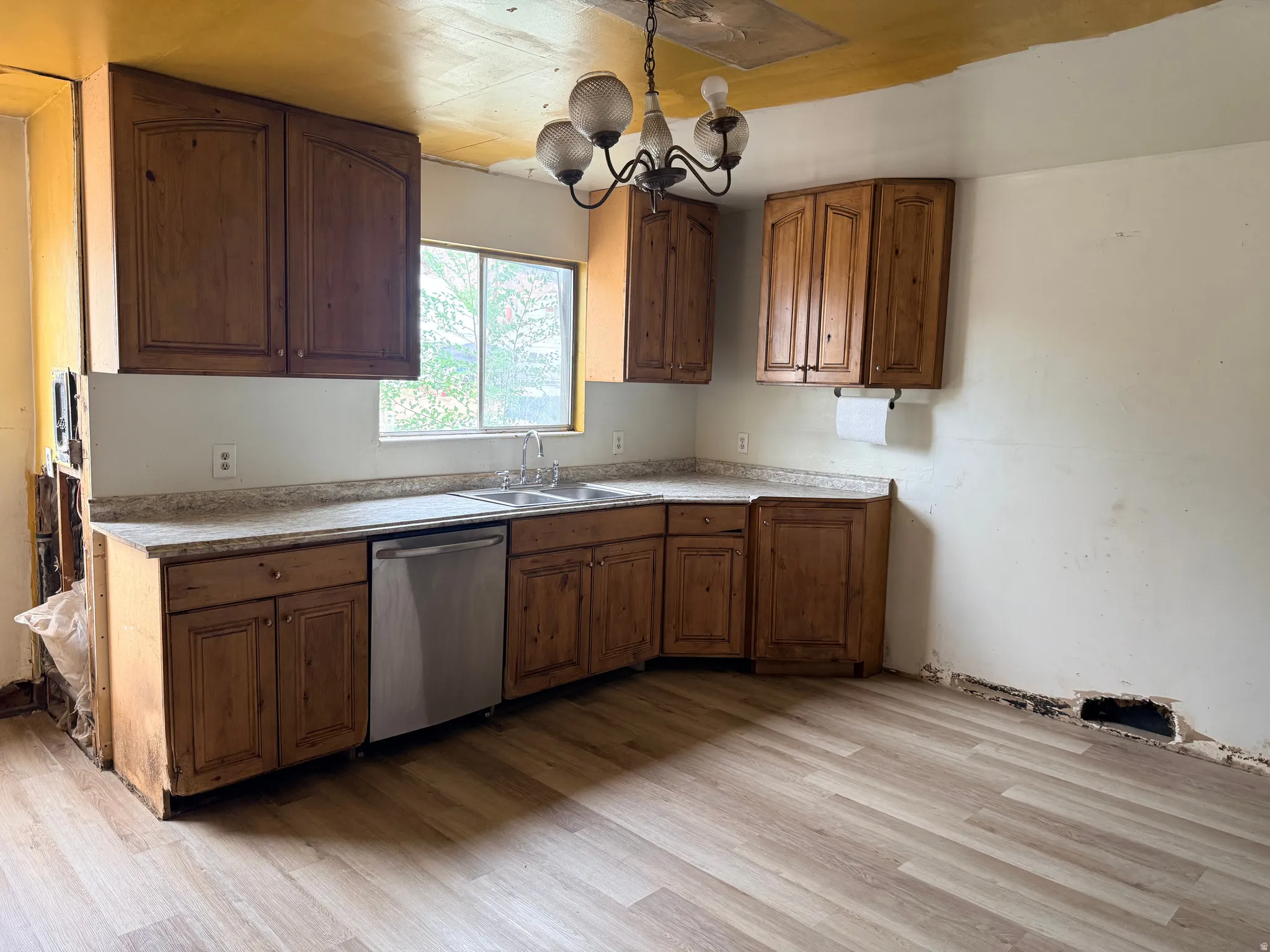 Wood-finish flooring with perimeter cabinetry and a built-in sink with a double basin