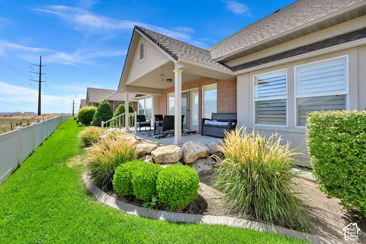 Covered patio with a gabled roof, brick exterior accents, and dual sliding glass doors