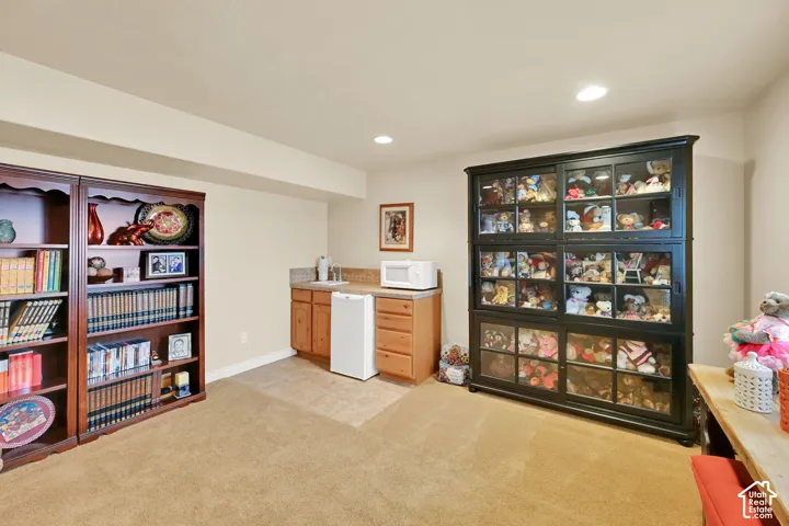 Built-in wet bar with wood cabinetry and tile backsplash