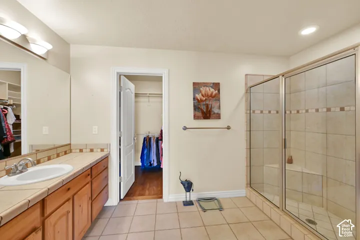 Wood-finish vanity with a drop-in sink and tiled countertop