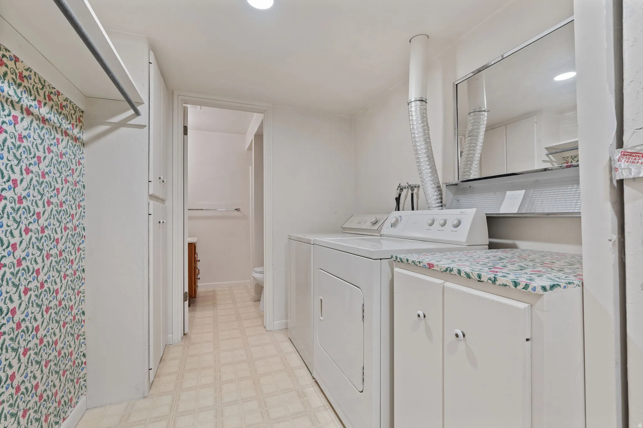 Laundry area with built-in cabinetry and patterned countertop