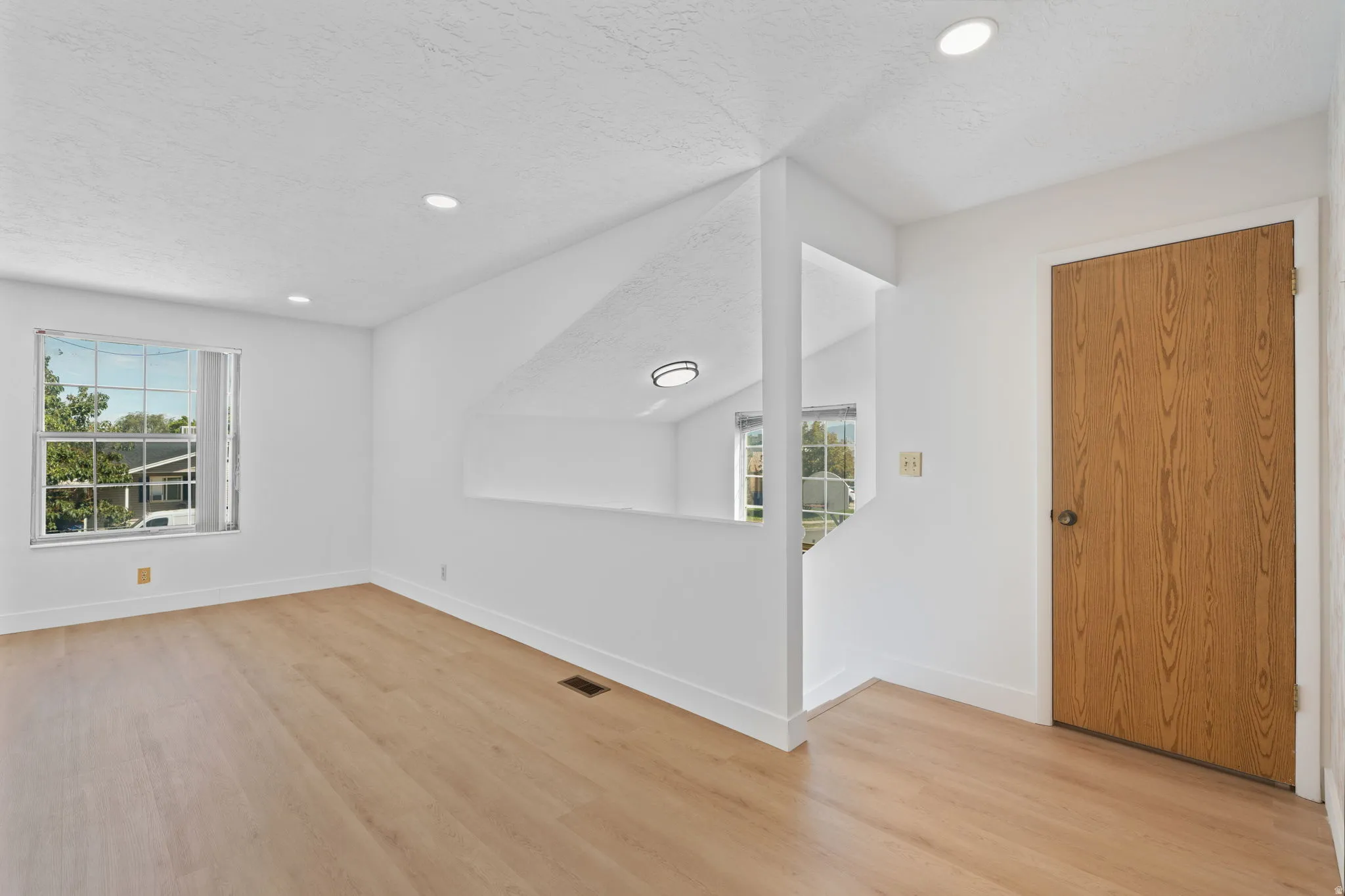 Light wood-finish flooring with white walls