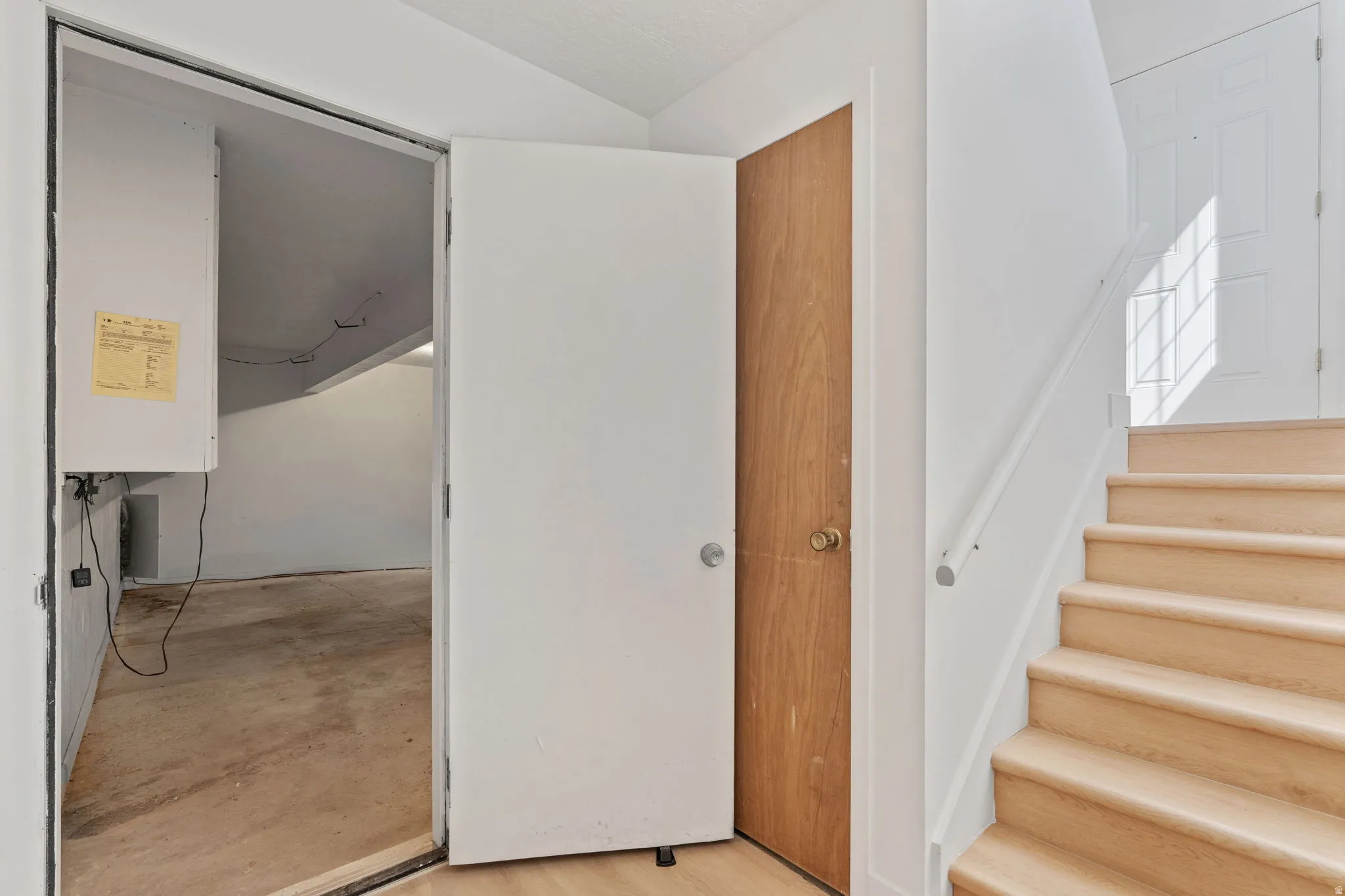 Hardwood staircase with a painted handrail and white risers