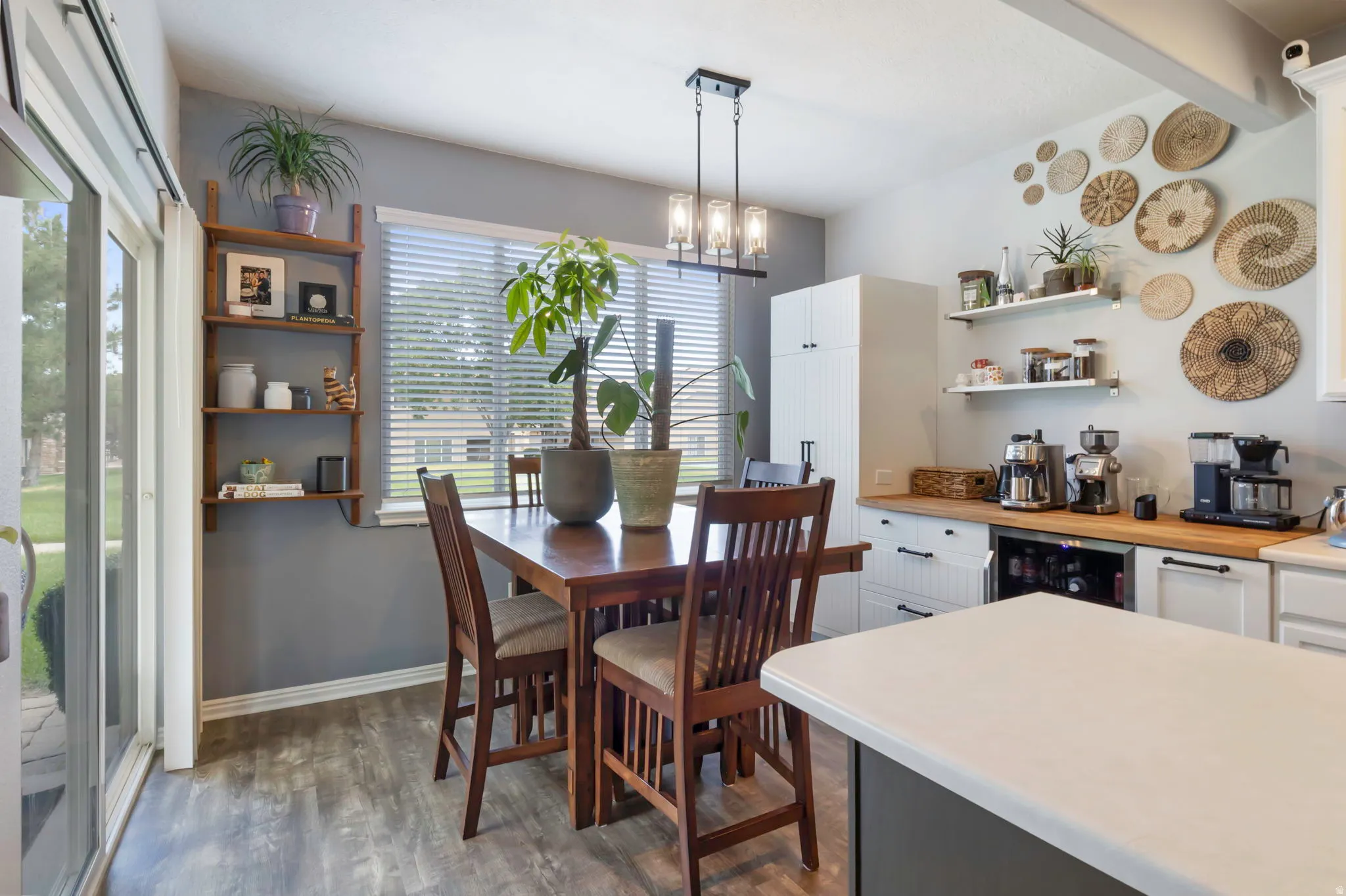 Dining area with wood-finish flooring, a sliding glass door, and a multi-light linear chandelier