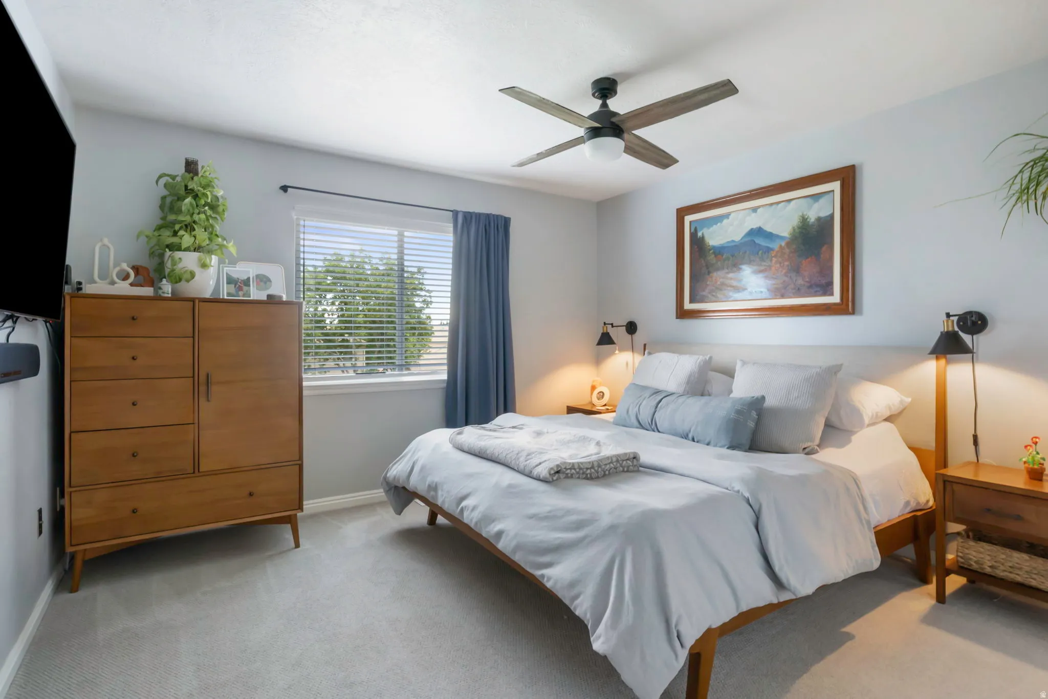 Primary bedroom with neutral wall color, wall-mounted light fixtures, window with blinds, ceiling fan