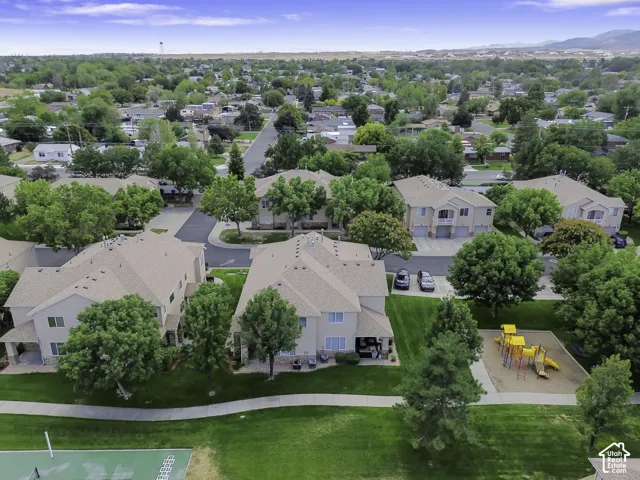 Residential community with multi-story buildings, surrounding green spaces, and mature trees