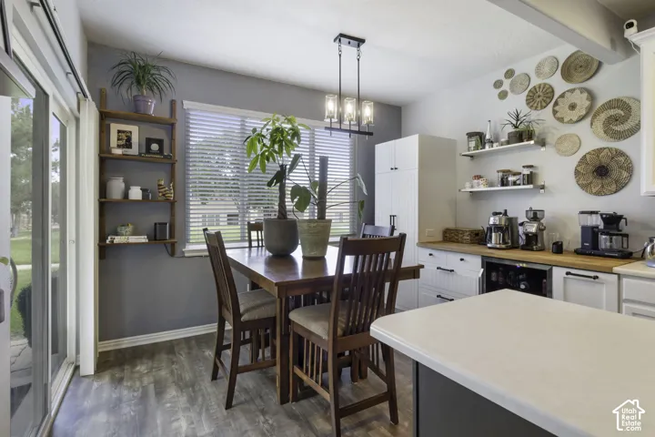 Dining area with wood-finish flooring, a sliding glass door, and a multi-light linear chandelier