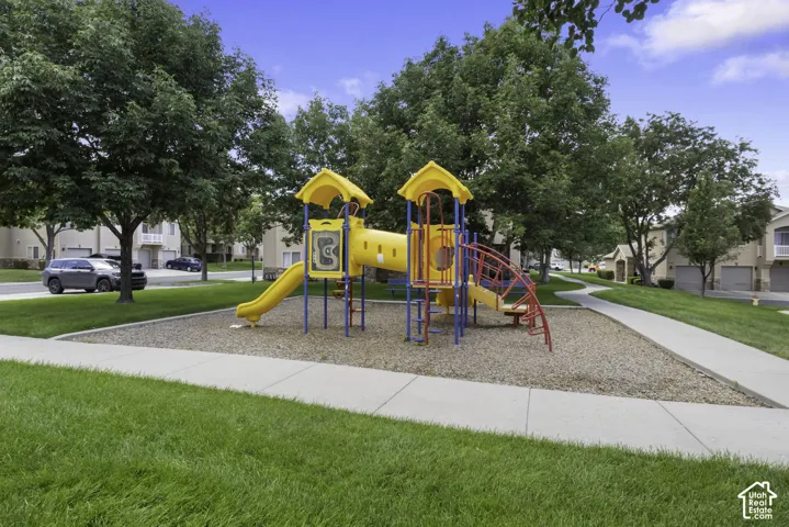 Community playground featuring a multi-level structure with slides and climbing elements outside your patio door and front door!