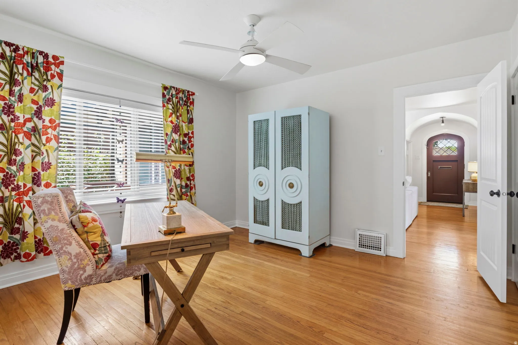 Bedroom 3 or office Hardwood flooring, white walls, window with blinds, ceiling fan with integrated lighting, and an arched entryway