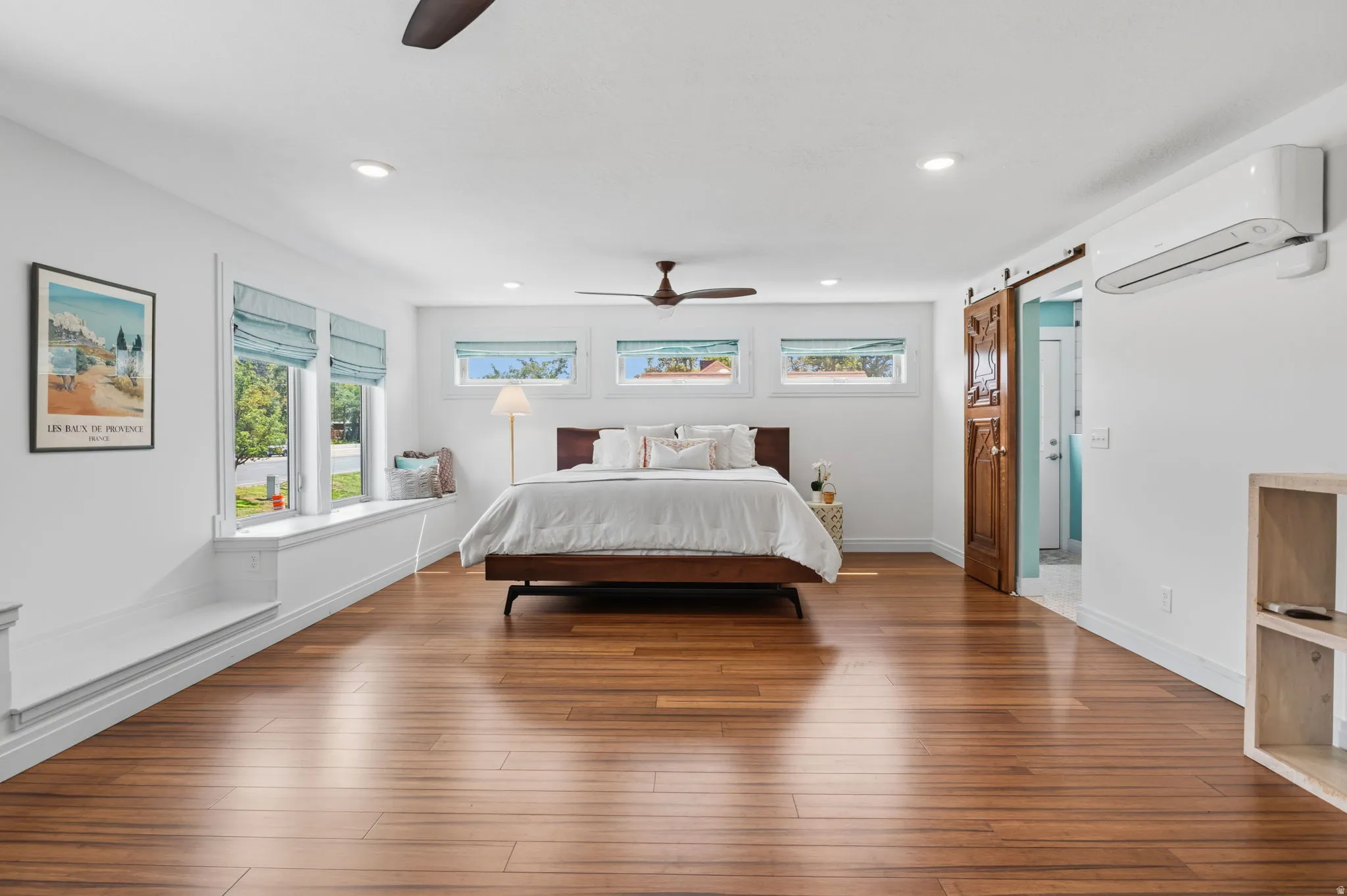 Primary Wood  flooring, recessed lighting, ceiling fan, built-in window seating, and a wood barn door