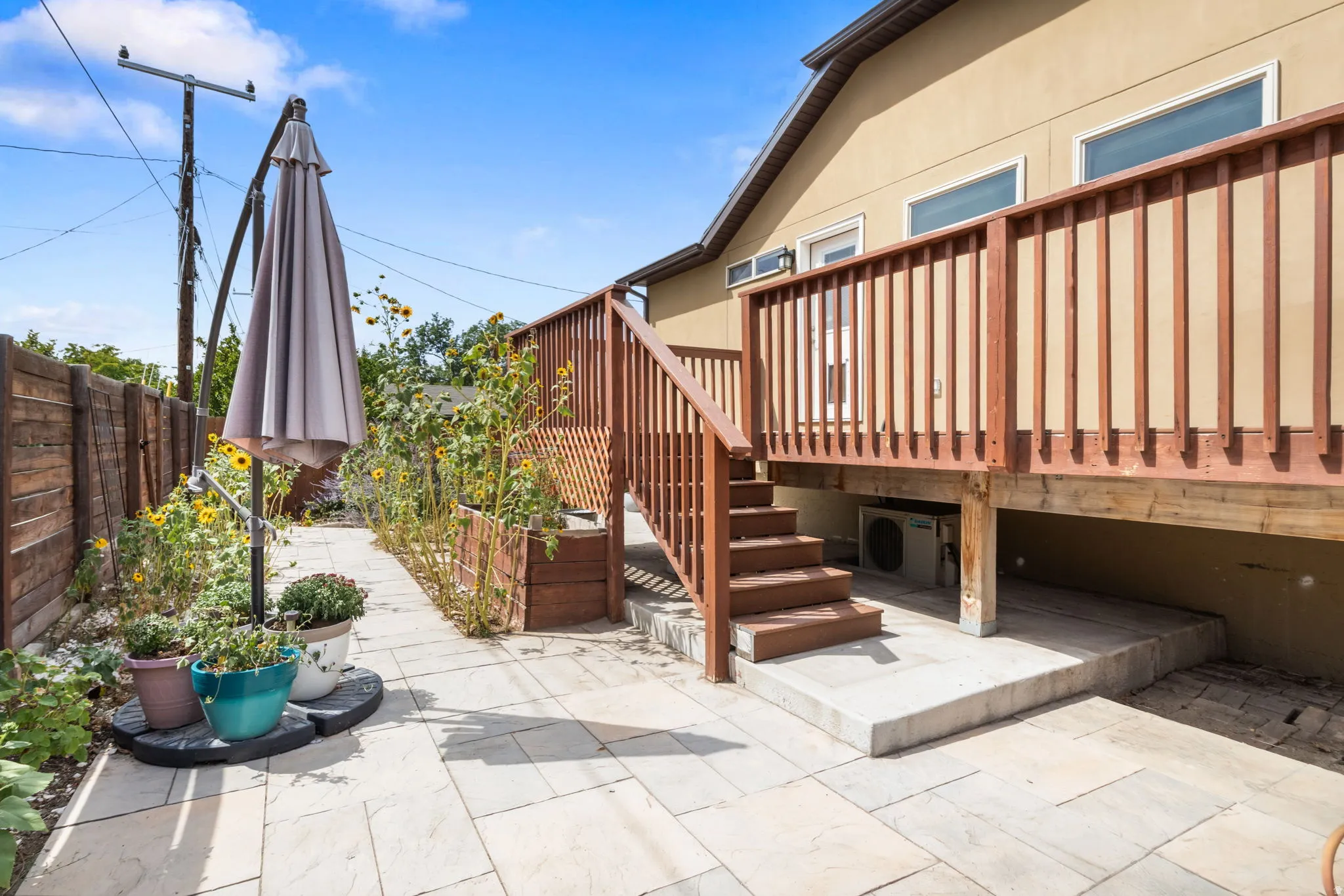 Spacious rear deck with wood railing, leading to a stone paver patio