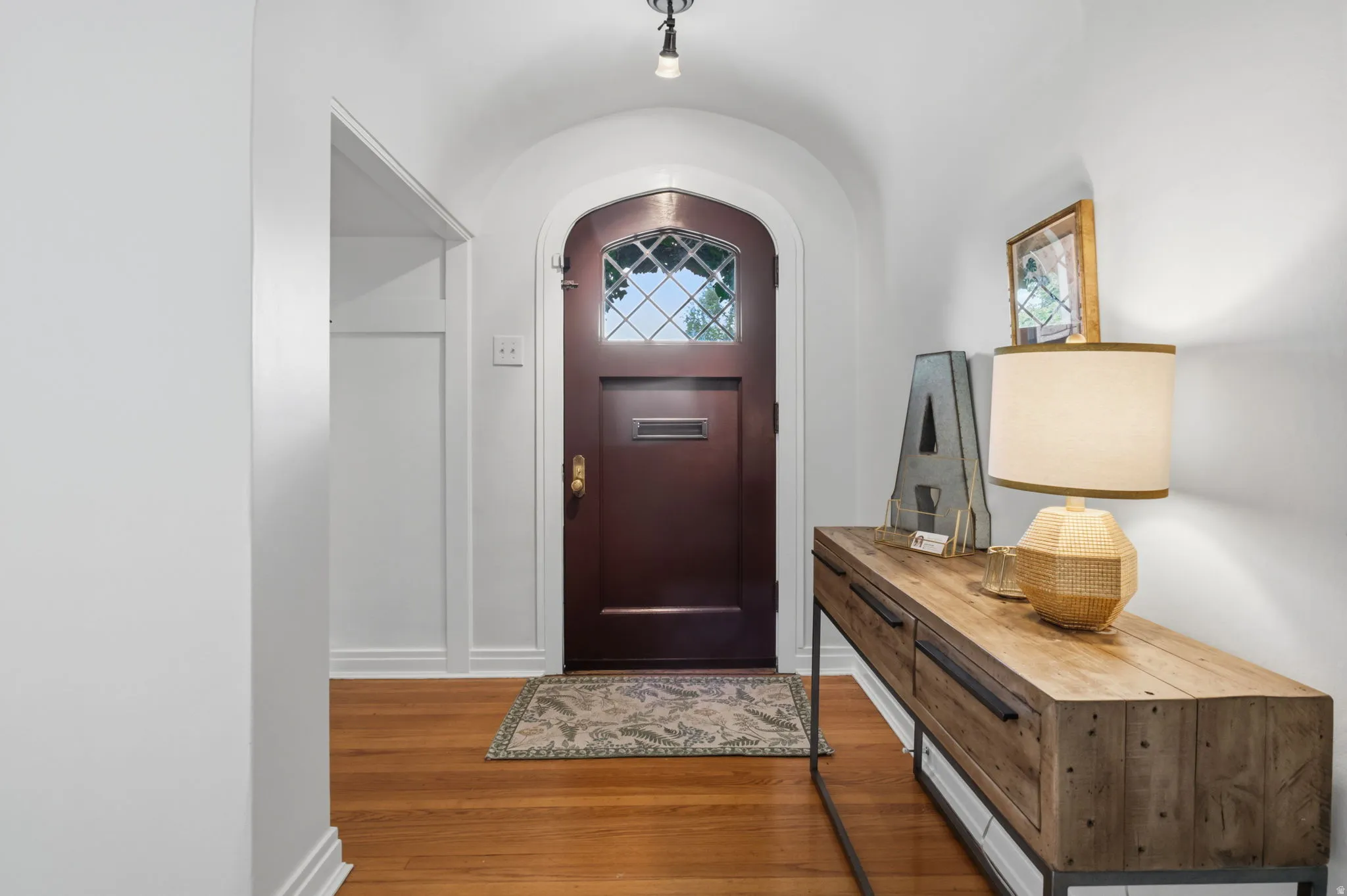 Arched entryway with a dark wood door featuring leaded glass