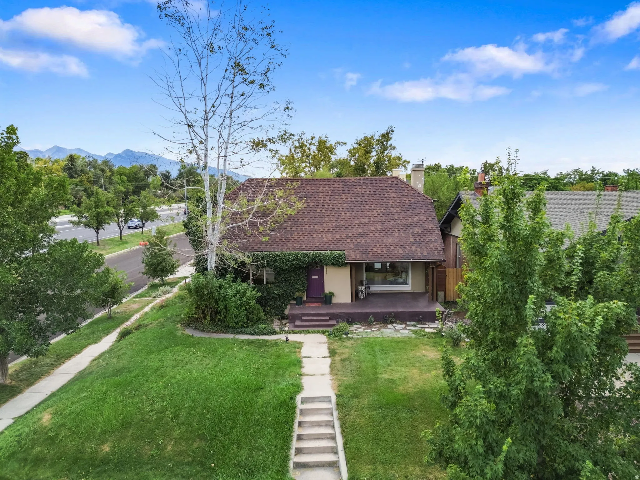 Gabled roofline, front porch, mature landscaping, and an established lawn