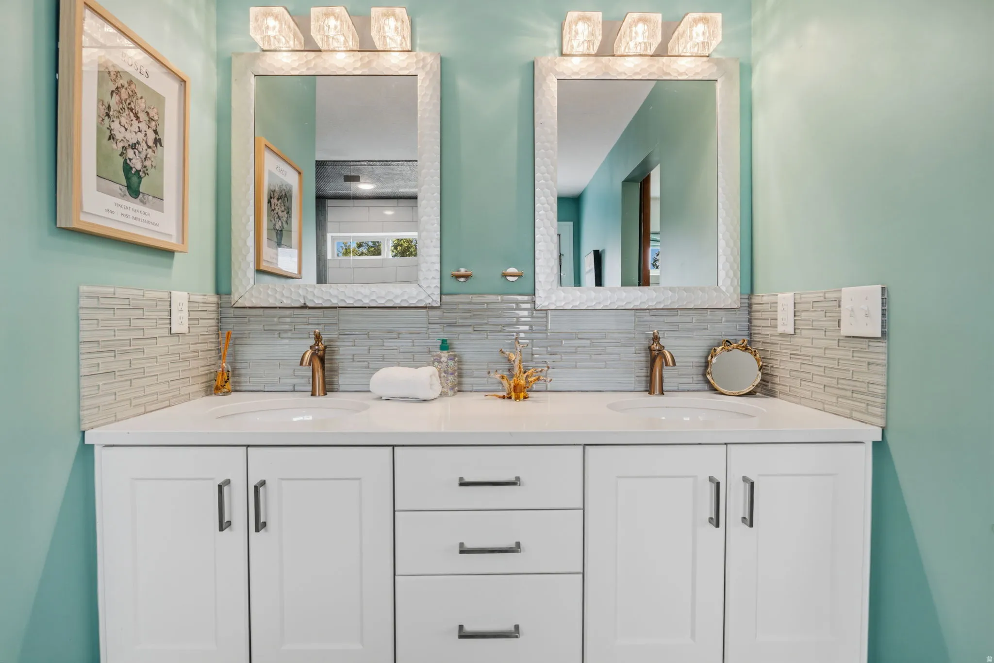 Dual vanities with white shaker cabinetry, white countertops, and bronze-finish fixtures