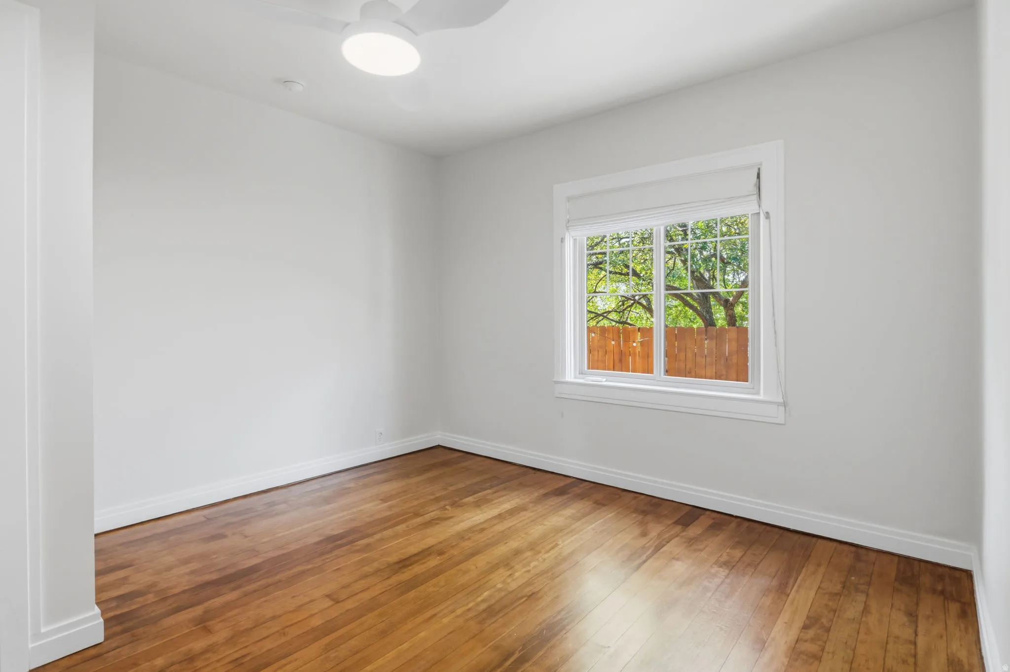 Bedroom 2 Hardwood flooring with white walls, a white ceiling fan, and a window with white trim