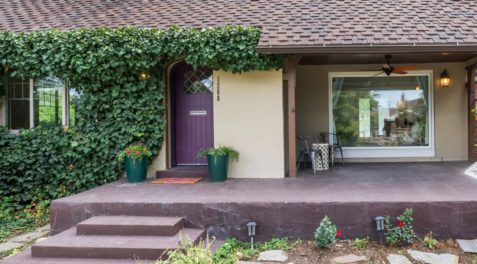 Inviting front entry featuring a purple-painted door, an archway, and an ivy-covered facade