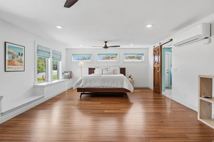 Primary Wood  flooring, recessed lighting, ceiling fan, built-in window seating, and a wood barn door