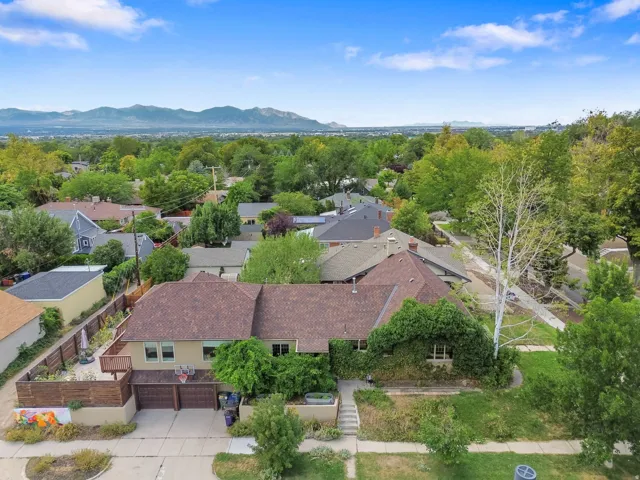Residential property with an attached two-car garage, mature landscaping, and a mountain backdrop