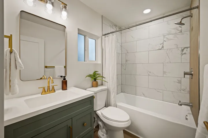 Integrated vanity with a gold-finish faucet and white countertop