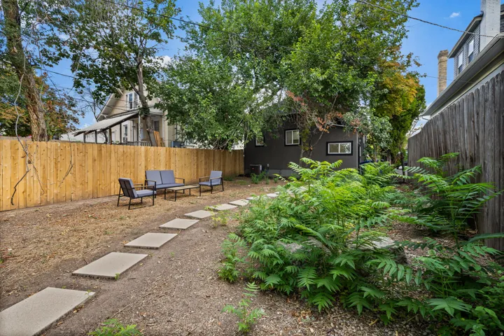 Private backyard featuring a new wood fence, concrete stepping stones, and established greenery