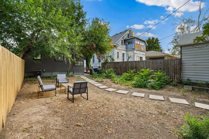Private backyard with new wood fencing, mature trees, and a paver stone pathway
