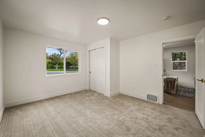 Neutral tone wall finishes, ceiling-mounted lighting, and carpeted flooring