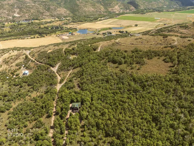 Mountainous landscape with expansive undeveloped terrain, featuring wooded areas and distant bodies of water