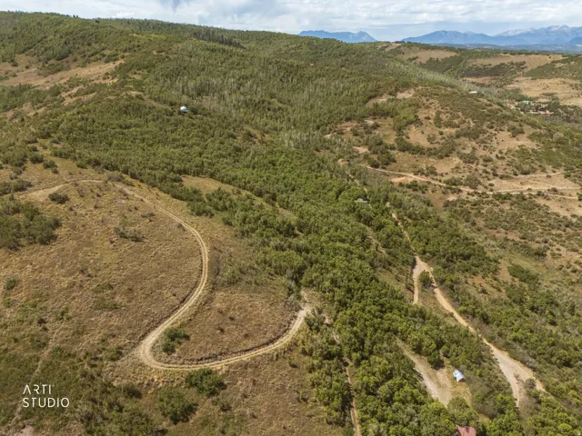 Expansive land with varied topography, including wooded areas and open terrain