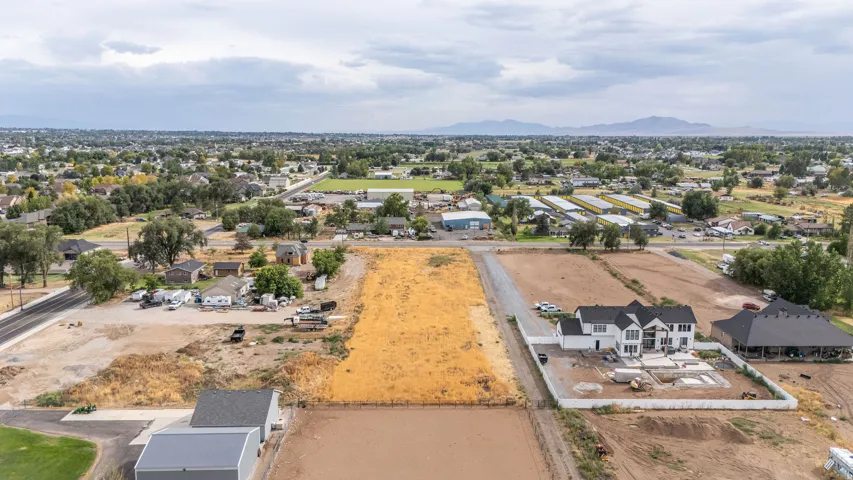 Expansive lot with partial gravel drive and visible foundation work