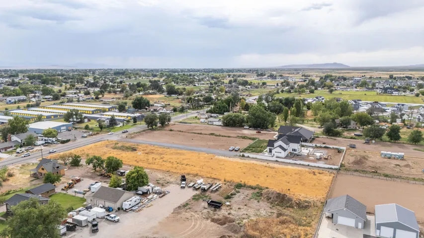Expansive land parcel featuring developed and undeveloped sections, adjacent to a structured residential area