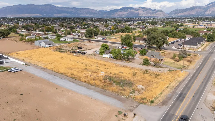 Expansive undeveloped parcel with a mountain backdrop, bordered by a paved road