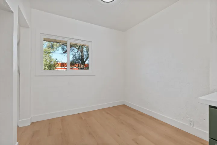 White walls, wood-finish flooring, and white trim